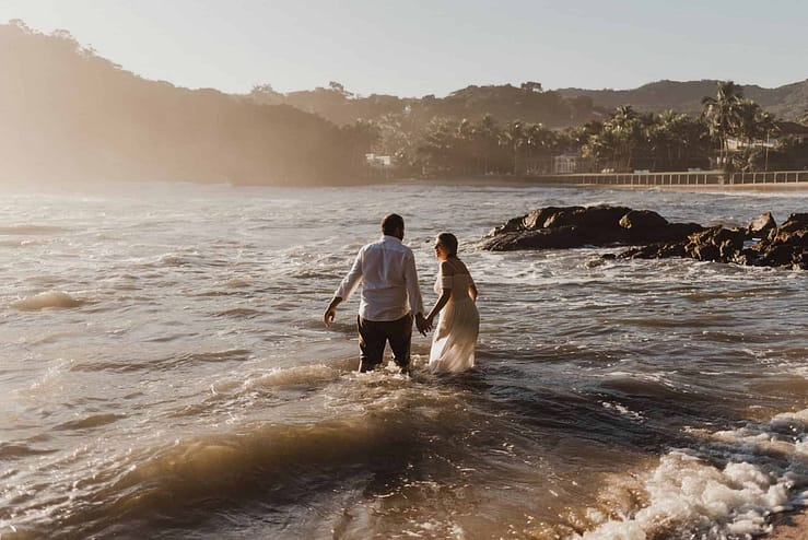 bruid-en-bruidegon-in-zee-met-trouwjurk-voor-fotoshoot